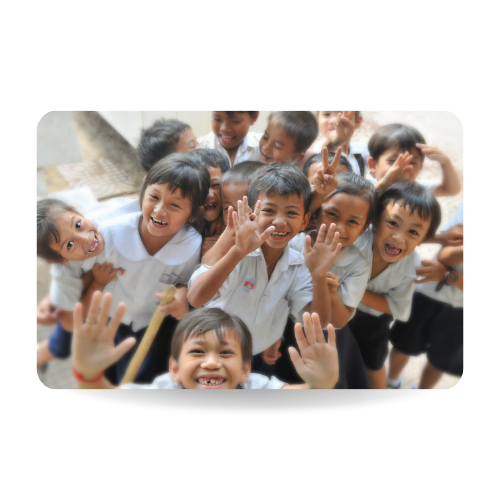 There is a group of happy students in primary school. They are all laughing and showing hands